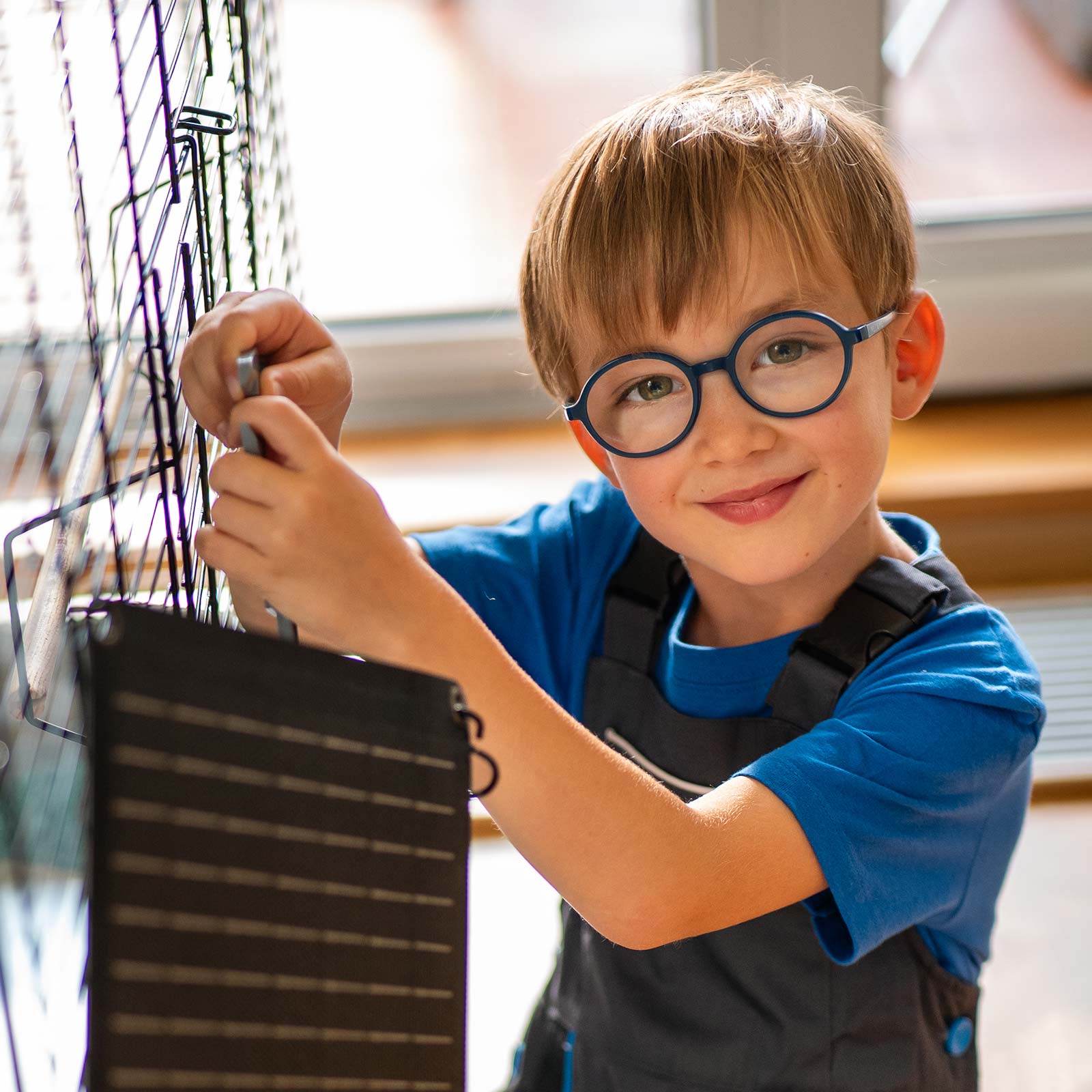 Malý kluk si hraje s hračkou - malou fotovoltaickou elektrárnou